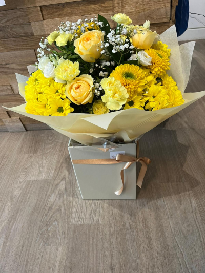 sunshine in a box - This beautiful white and yellow hand tied bouquet would brighten anyone's day! With roses, chrysanthemums, carnations and gypsophilia tied together in a bubble of water.